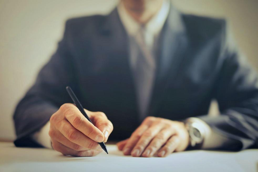 Closeup of a man signing documents