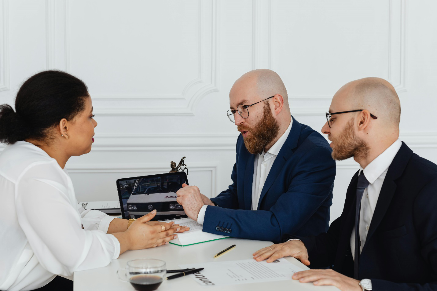 a woman sitting in front of two lawyers
