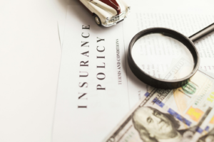 a dollar bill and magnifying glass on top of an insurance policy document