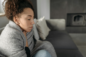 a woman sitting down wrapped in a blanket
