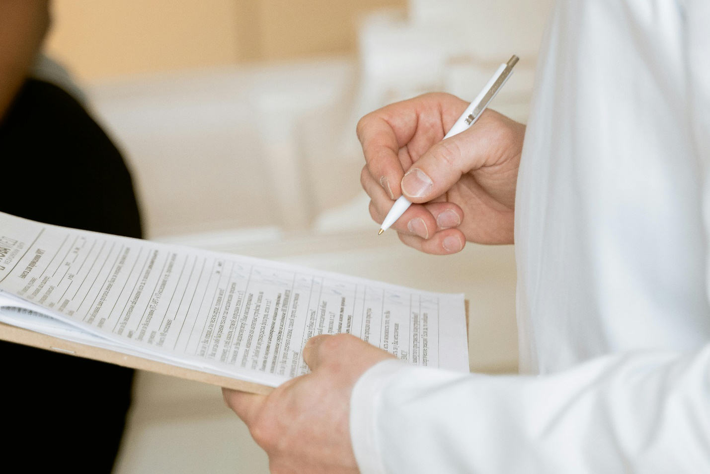 photo of a person holding a pen and medical form