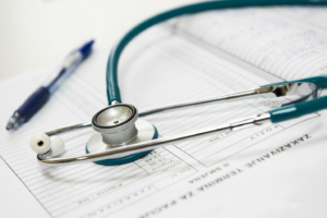 a pen and stethoscope on top of a medical report