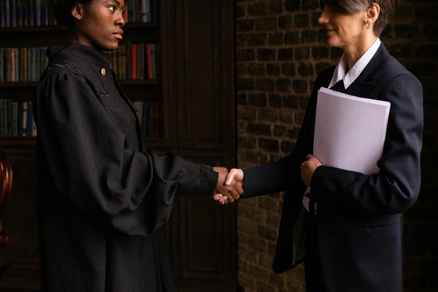 a female judge shaking hands with a female lawyer