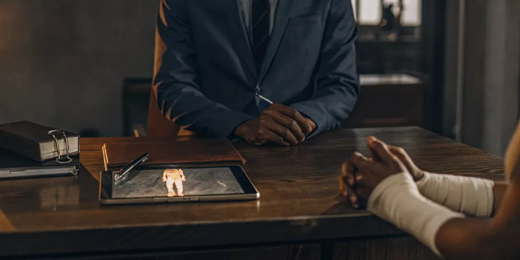 Burn injury lawyer advising a client with bandaged hands on their legal claim.